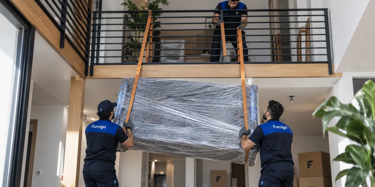 Furnigo ekibi ambalajlı mobilyayı kayışla üst kata çıkarırken